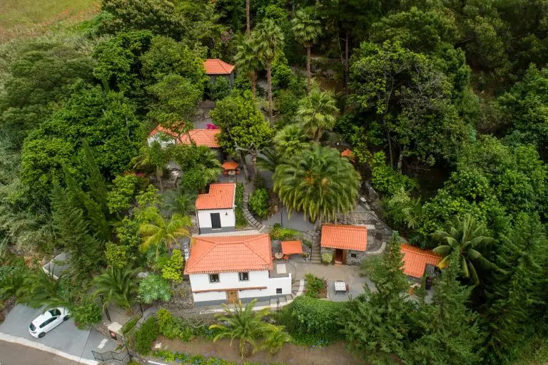 Luchtfoto van de drie stenen vakantiehuizen en groene tuinen van Casas da Terça in Tábua op Madeira