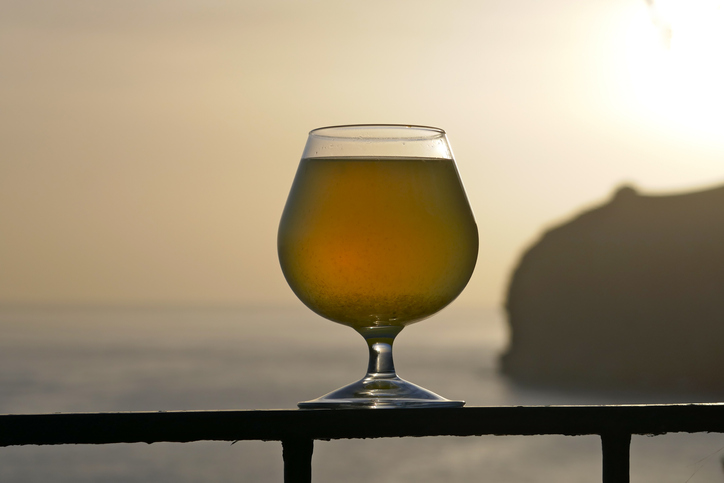 Glas poncha bij zonsondergang aan de kust