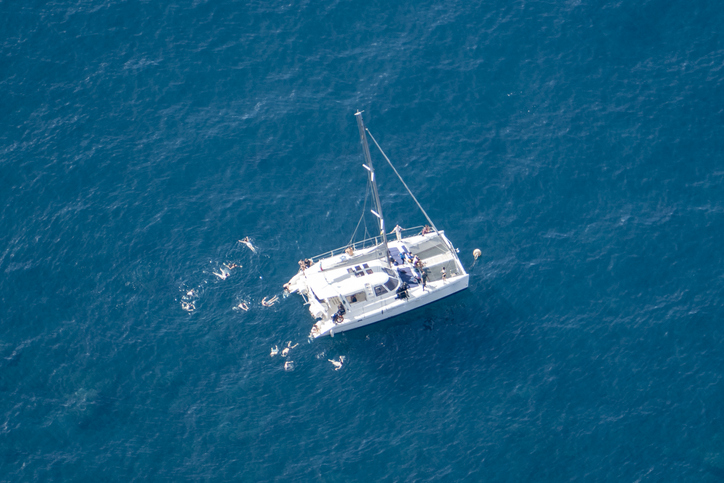 Boot en zwemmers voor de klif van Cabo Girão