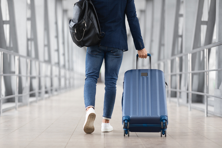 Reiziger loopt met koffer door een luchthaven