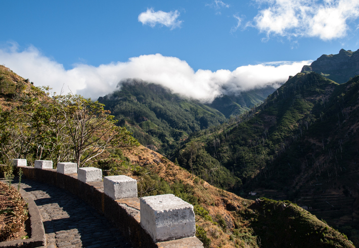 Wolken rond de bergen van Madeira met zon boven de kust